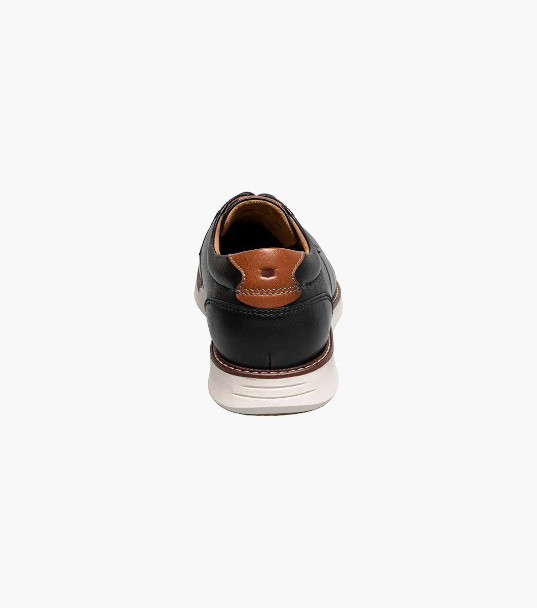 Black leather shoe with brown lining on a white background