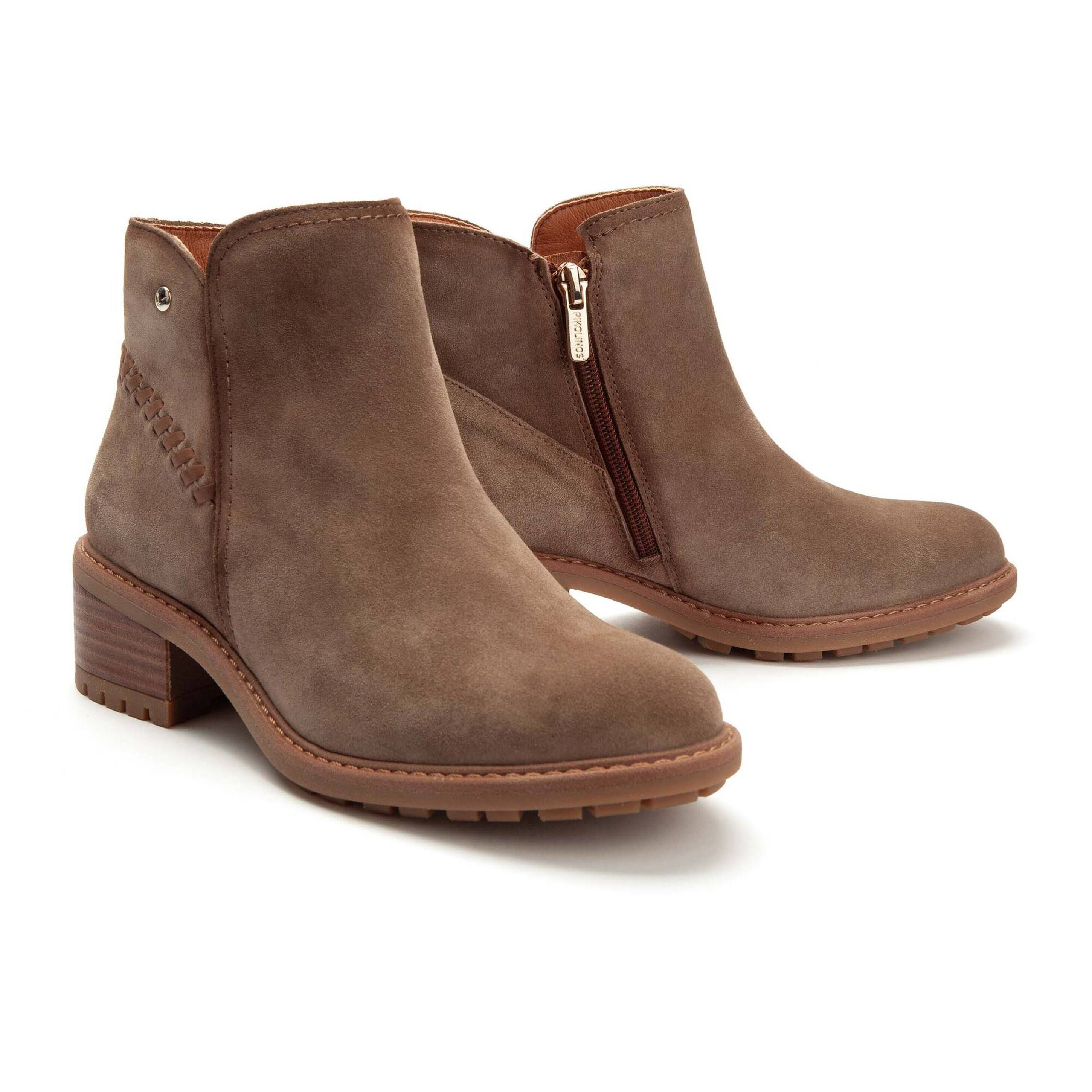A pair of women's brown suede ankle boots with a low block heel, side zipper, and decorative stitching on a clean white background.