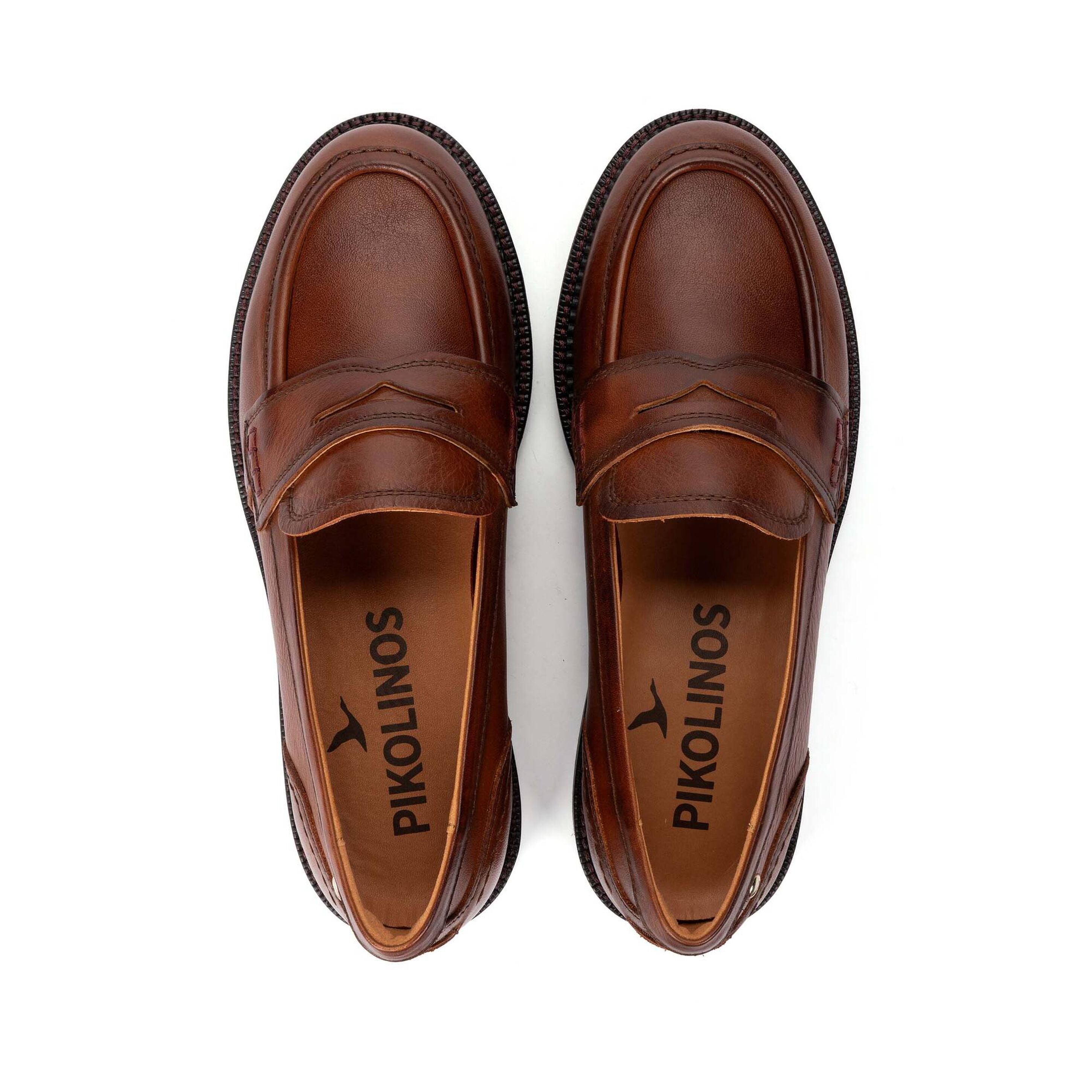 A pair of brown leather penny loafers shown from a top-down view on a white background, with the brand name 'PIKOLINOS' printed on the insoles.