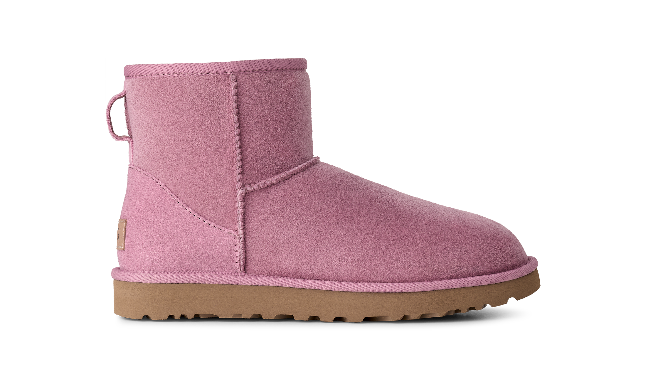 A single pink suede ankle boot with a tan rubber sole, shown in a side profile on a solid white background.