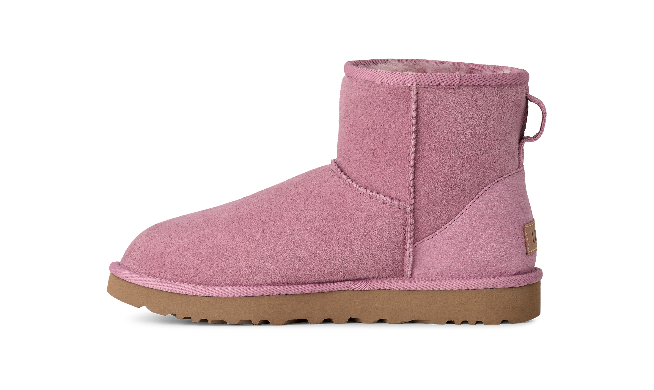 A single pink suede ankle boot with a tan sole, shown in a side profile on a solid white background.
