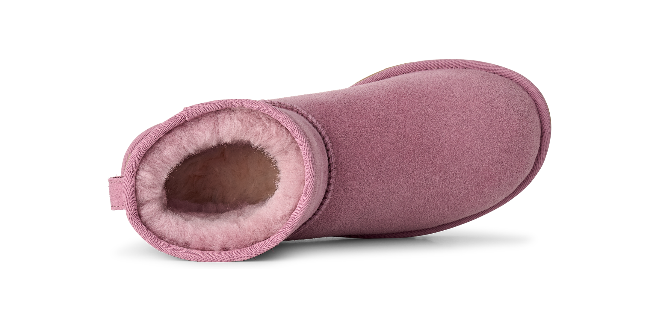 A single dusty pink suede ankle boot with a plush pink shearling lining, shown from a side profile view on a white background.