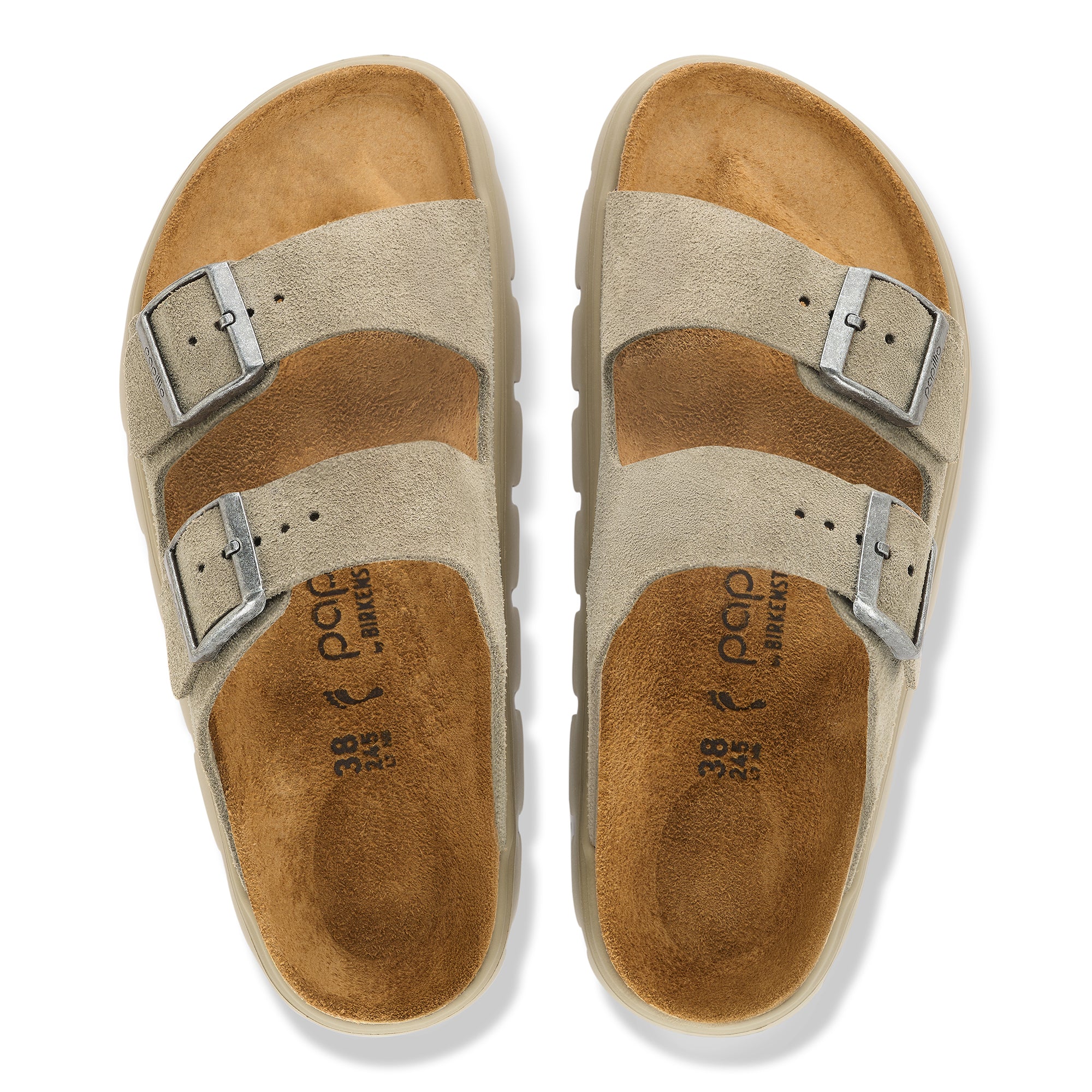 Pair of tan sandals with metallic buckles on a white background