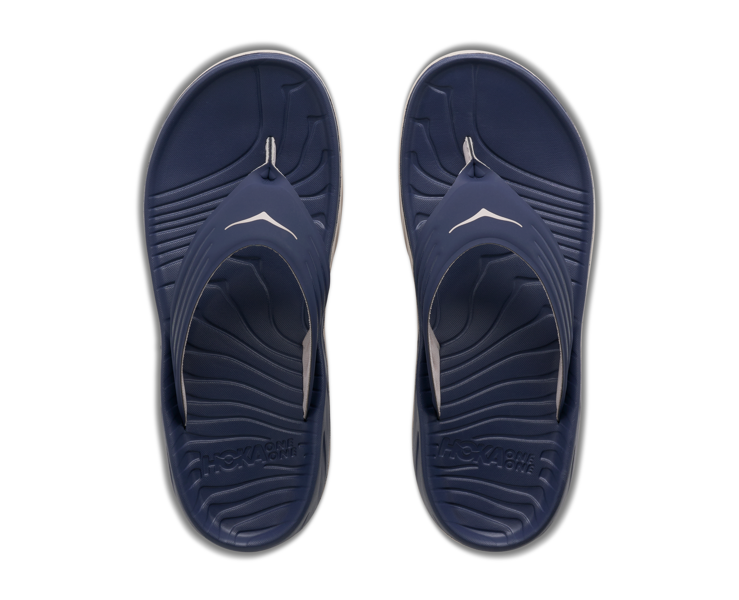 Pair of navy blue sandals with a white logo on a white background