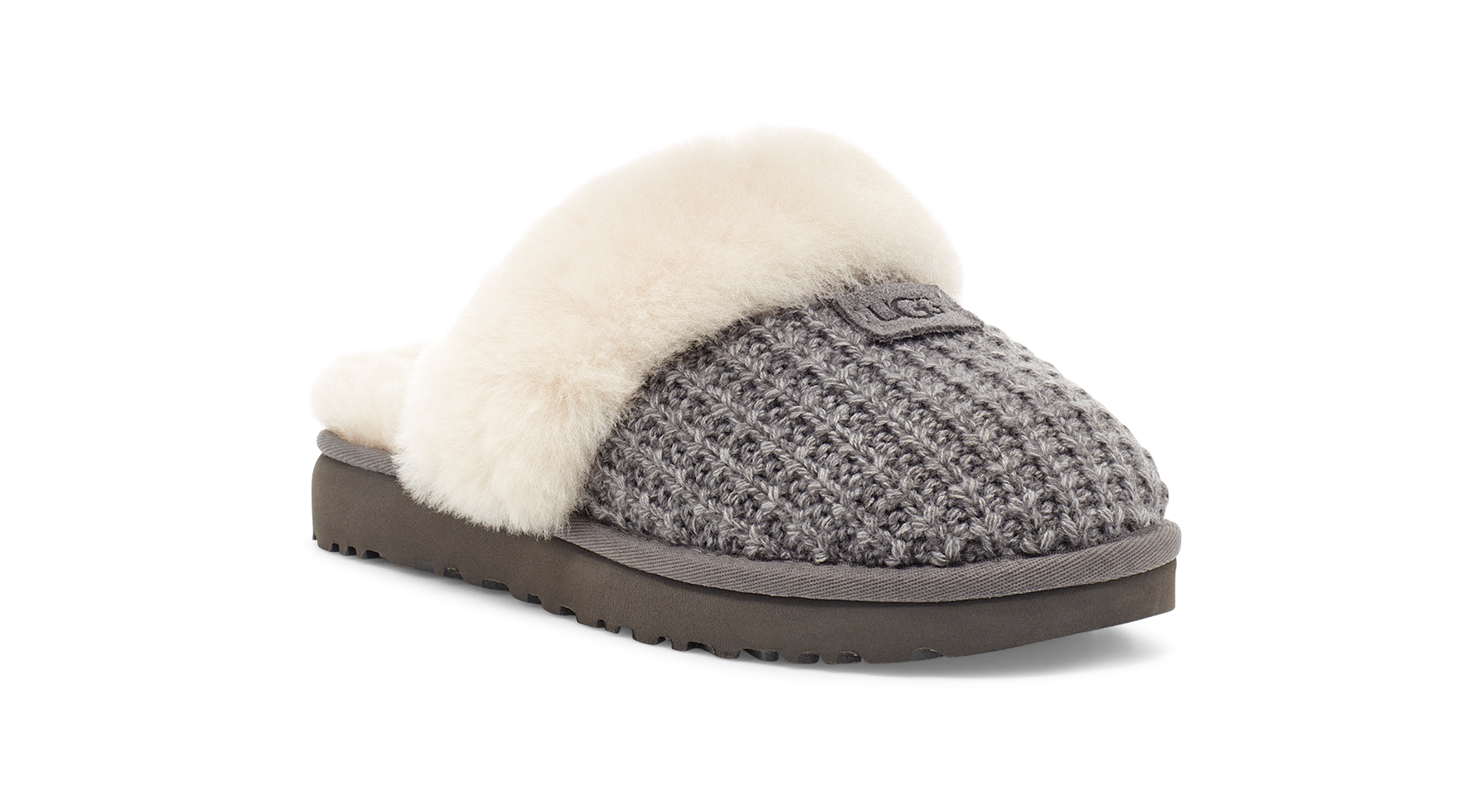 A single UGG slip-on slipper shown from a three-quarter angle on a white background. The slipper features a gray textured knit upper, a soft cream-colored shearling lining, and a dark brown sole.