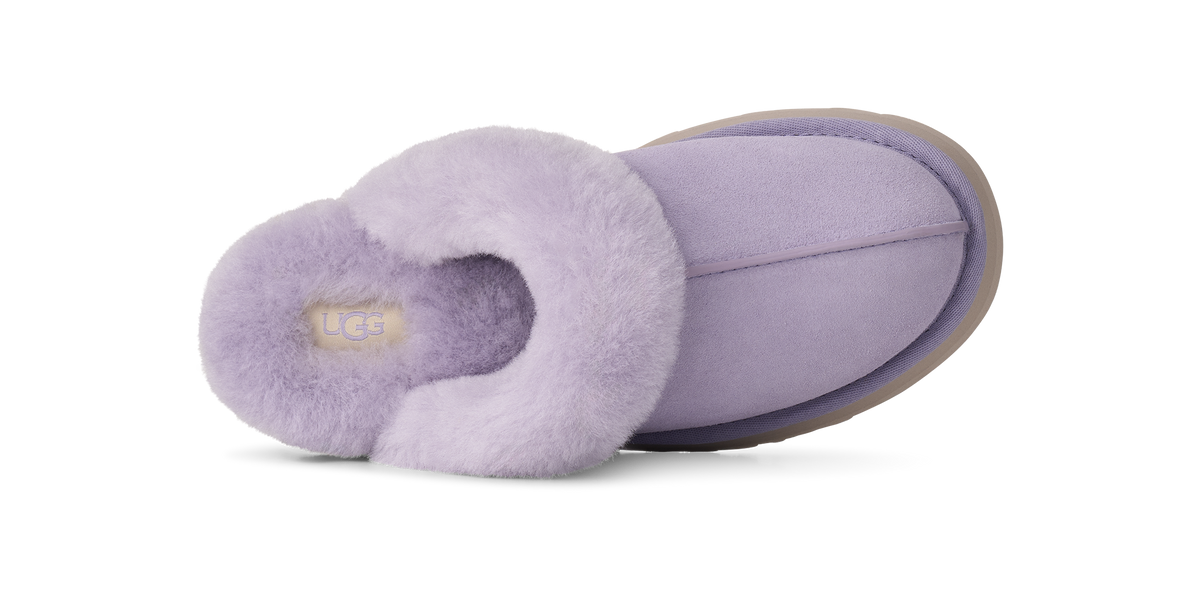 A single UGG slipper in light purple/lavender suede with a fluffy faux-fur trim, shown from a side profile view on a white background.