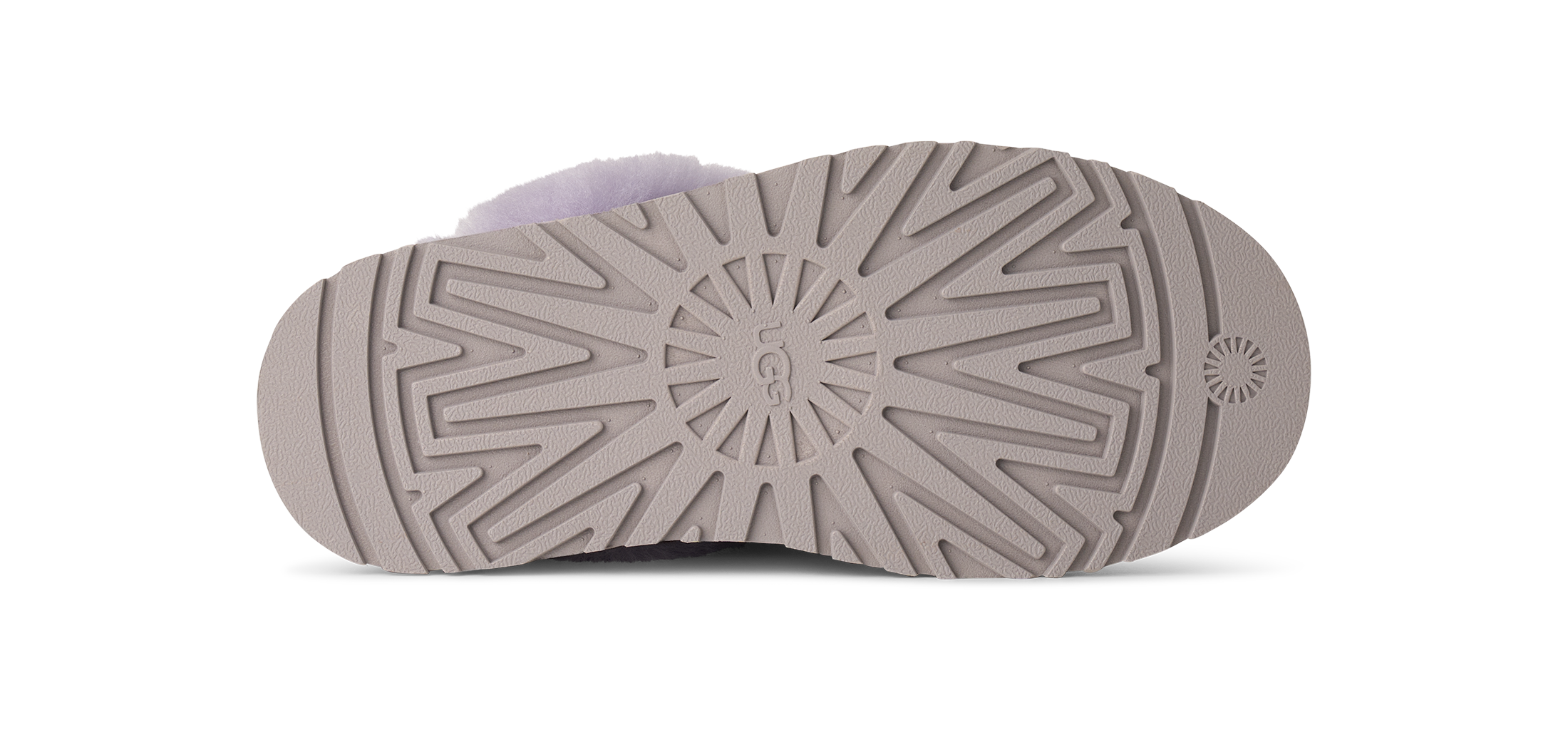 The sole of a UGG slipper in a taupe-brown color, showing the tread pattern and the embossed UGG logo in the center, with a light lavender fuzzy lining visible at the top edge.
