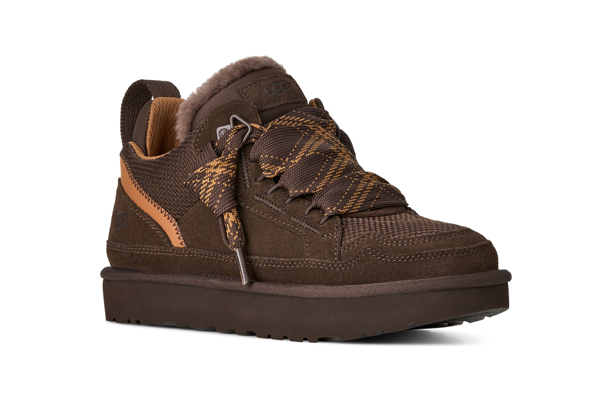 A brown low-top lace-up shoe with a fuzzy brown collar, brown textured overlays, and a thick brown sole, shown on a plain white background.