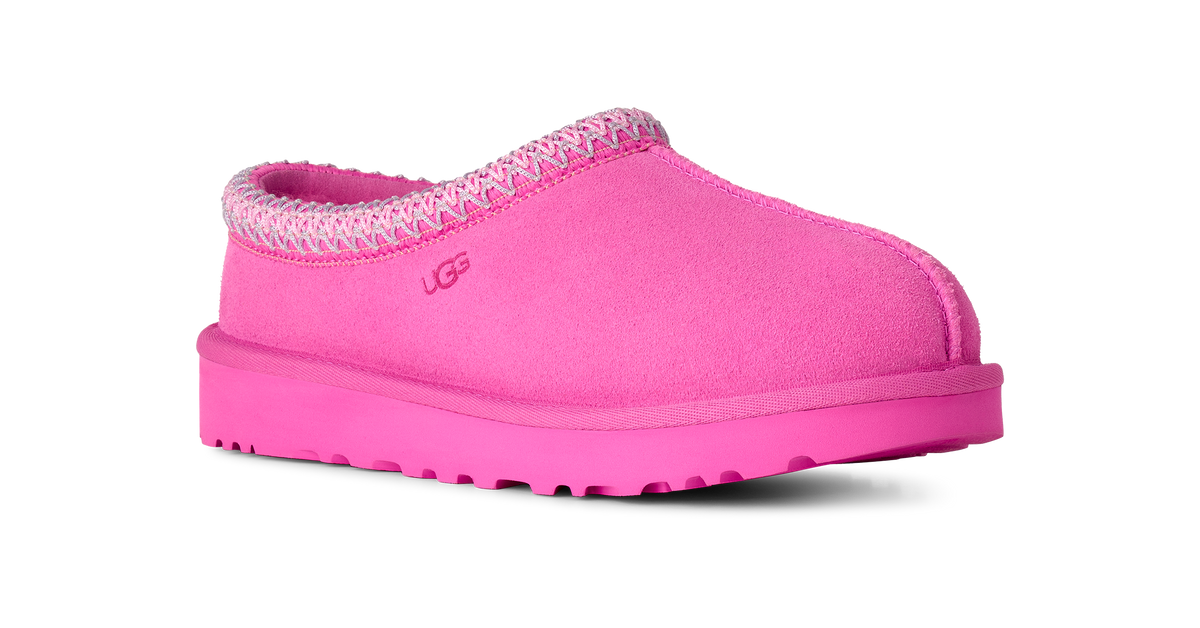 A single UGG slip-on clog shoe in bright pink suede with a matching pink sole and a pink and white patterned trim around the collar, shown on a plain white background.