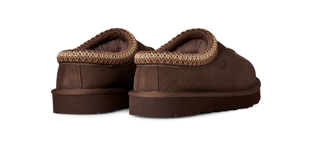 A pair of brown slip-on slippers with a textured knit trim around the collar, shown from a three-quarters angle on a white background.