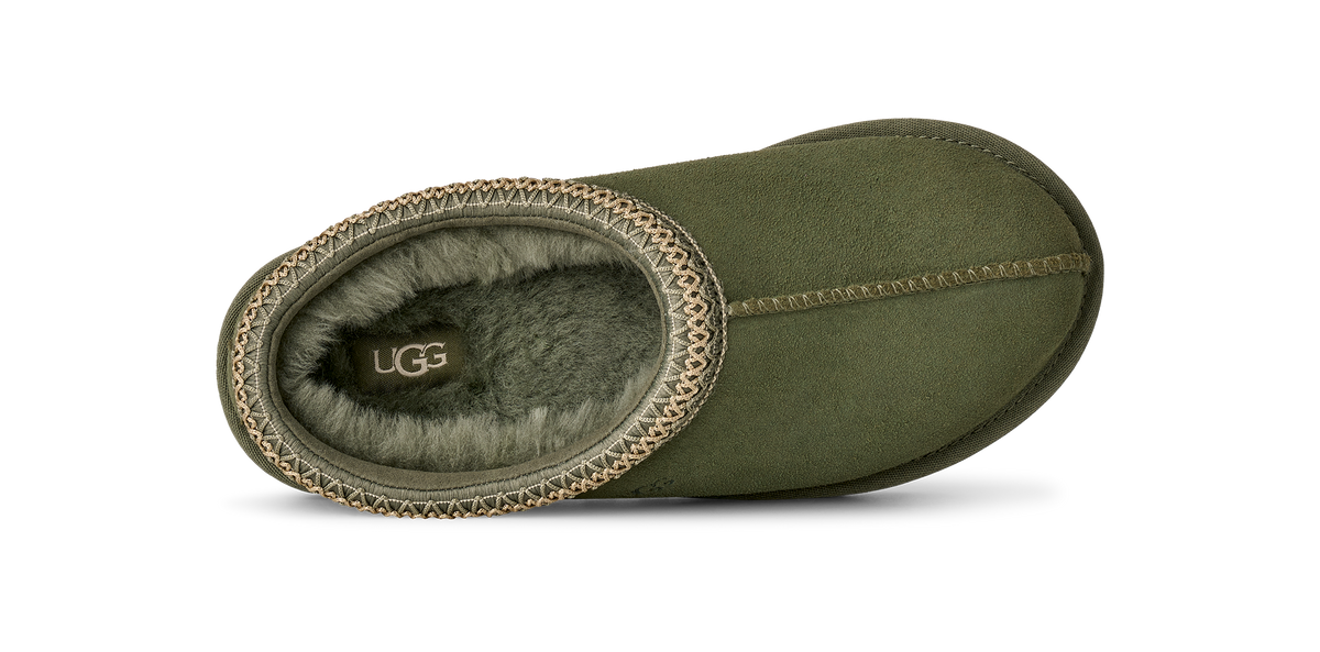 An olive green suede UGG slipper shown from a top-down view, featuring a soft gray shearling lining and a decorative braided trim around the opening.