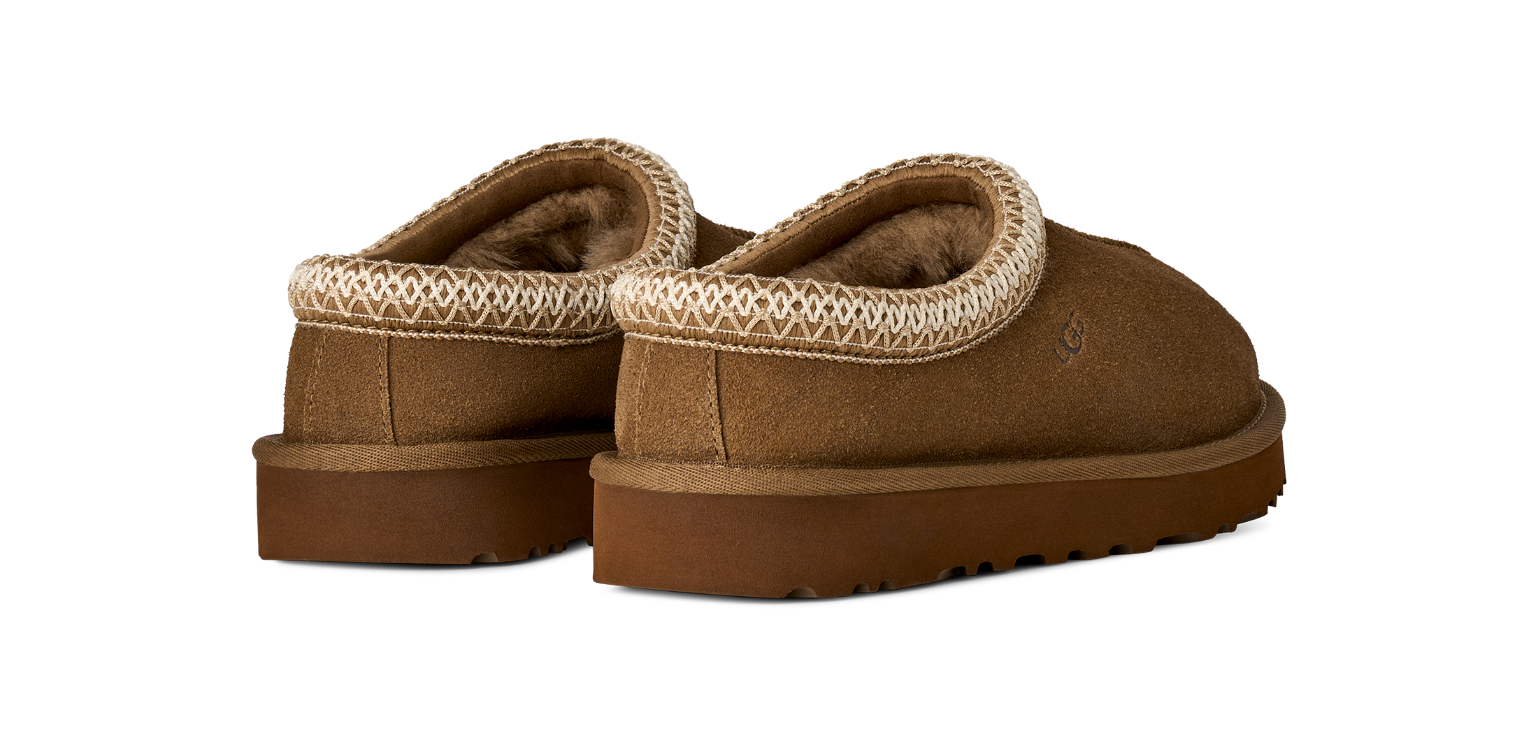 A pair of brown suede slip-on slippers with a textured cream knit trim around the collar and a plush brown lining, shown from a three-quarters angle on a white background.