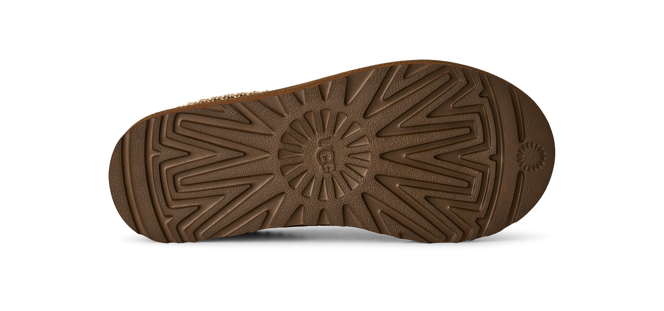 The brown rubber outsole of a boot, showing a detailed tread pattern and a small embossed logo on the heel, photographed against a solid white background.