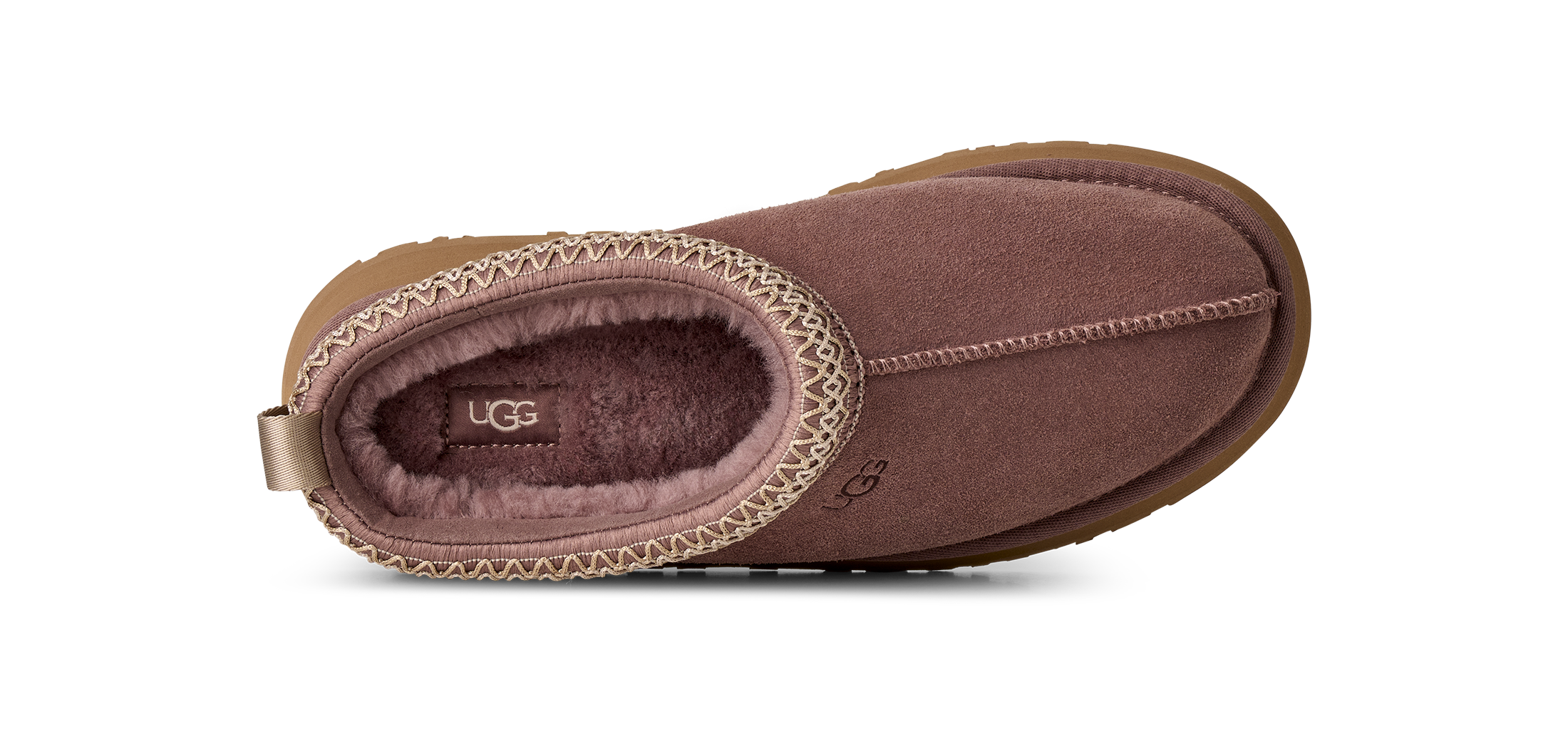 A single UGG slipper shown from a top-down view on a clean white background. The slipper features a dusty rose-brown suede exterior, a matching fuzzy interior, and a decorative stitched trim around the opening.