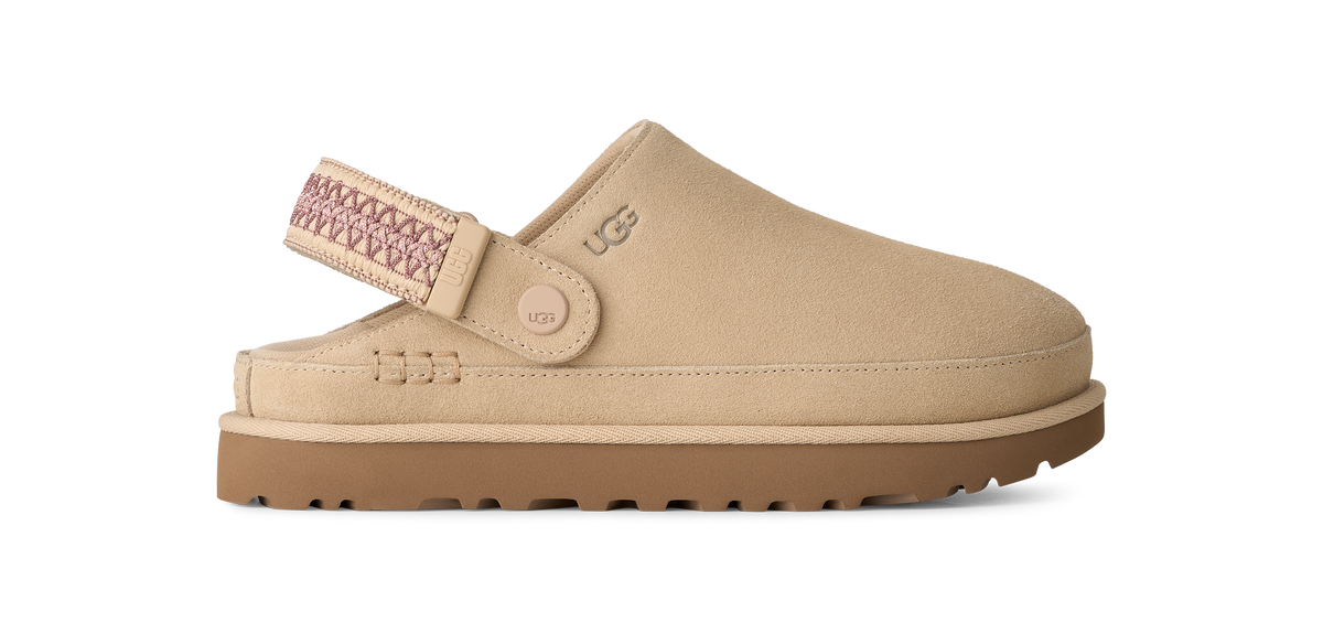 A beige UGG clog shoe with a brown sole and a pink patterned strap, shown from a side profile on a white background.