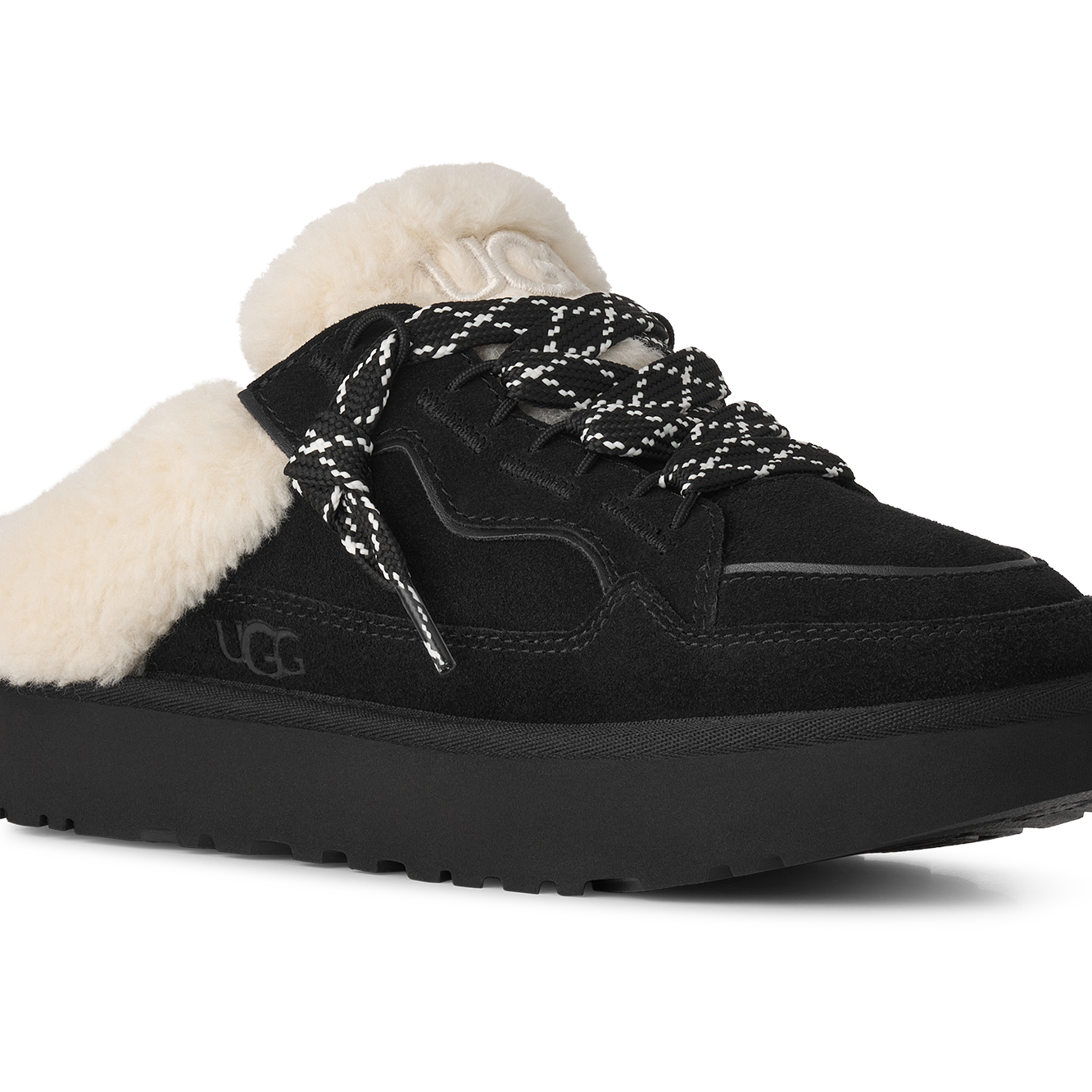 A black UGG platform slipper shoe with fluffy white shearling lining and black-and-white patterned laces, shown from a three-quarters angle on a white background.