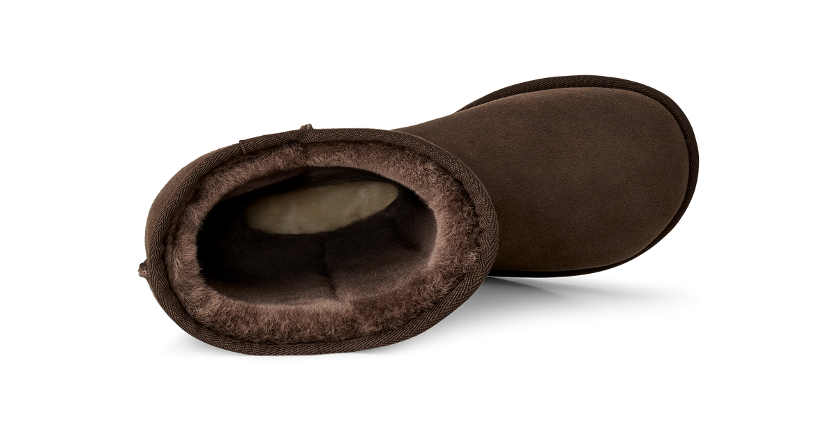 A single brown suede slipper boot with a plush brown shearling lining, shown from a side profile view on a white background.