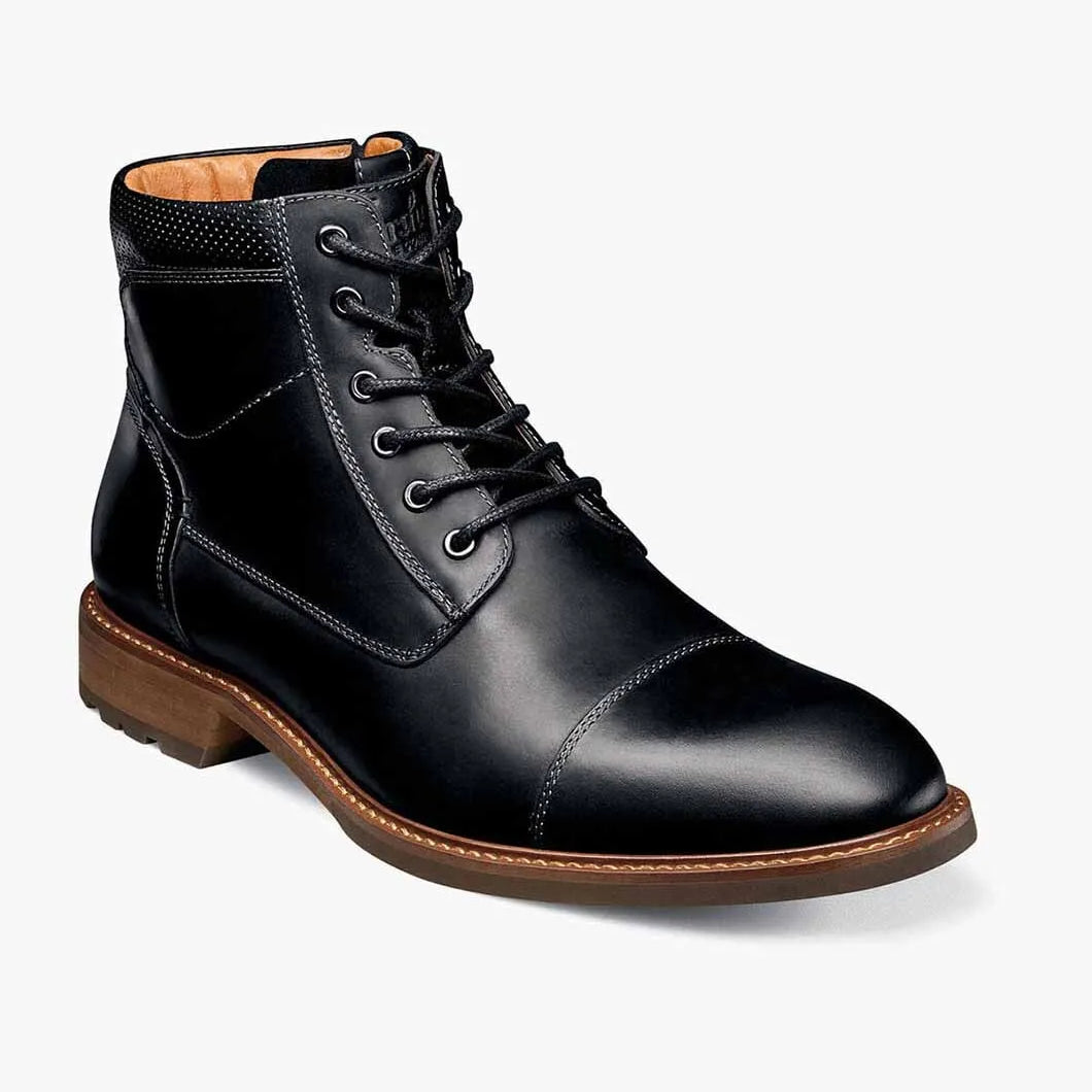 Black leather boot with brown sole on a white background