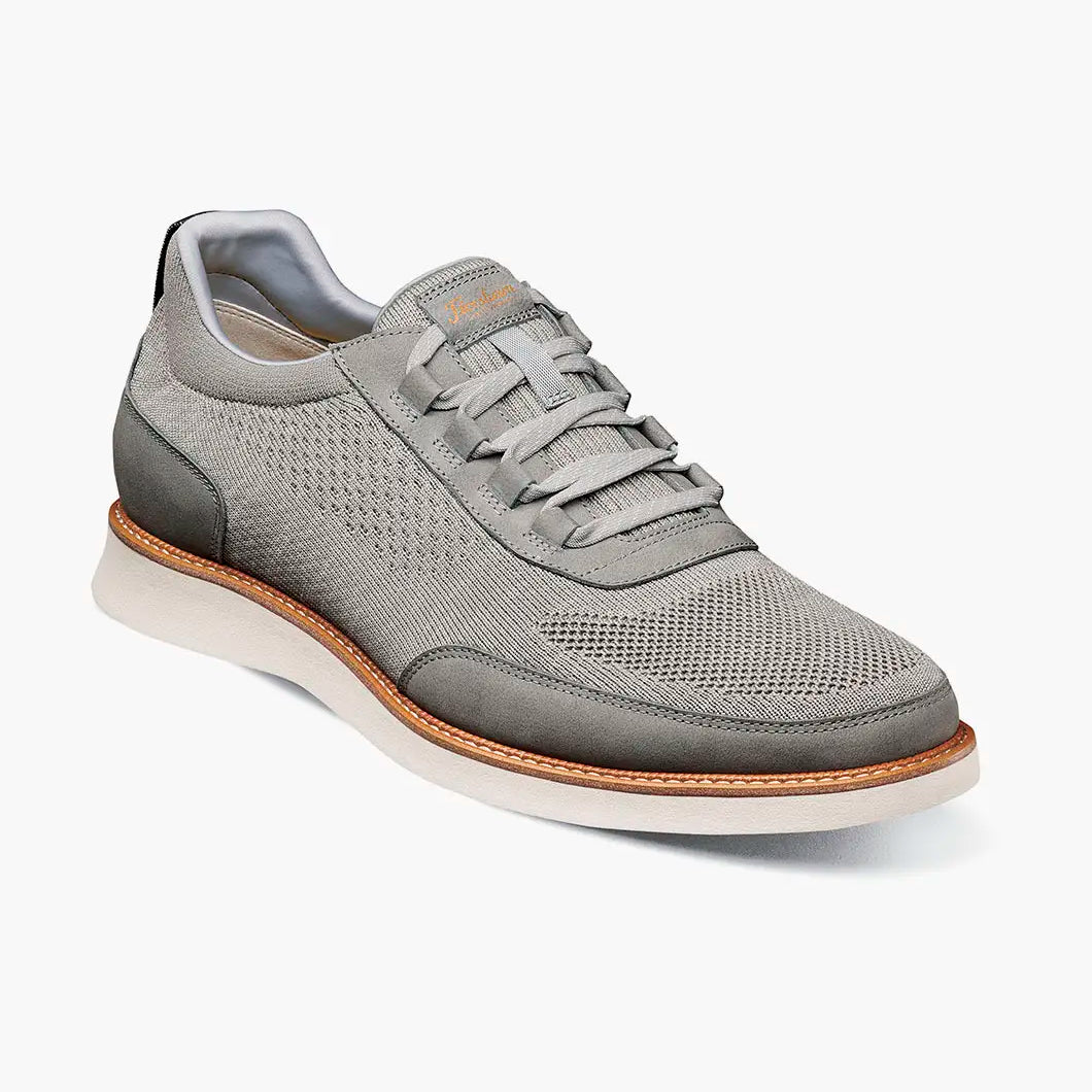 Gray sneaker with a brown sole on a white background