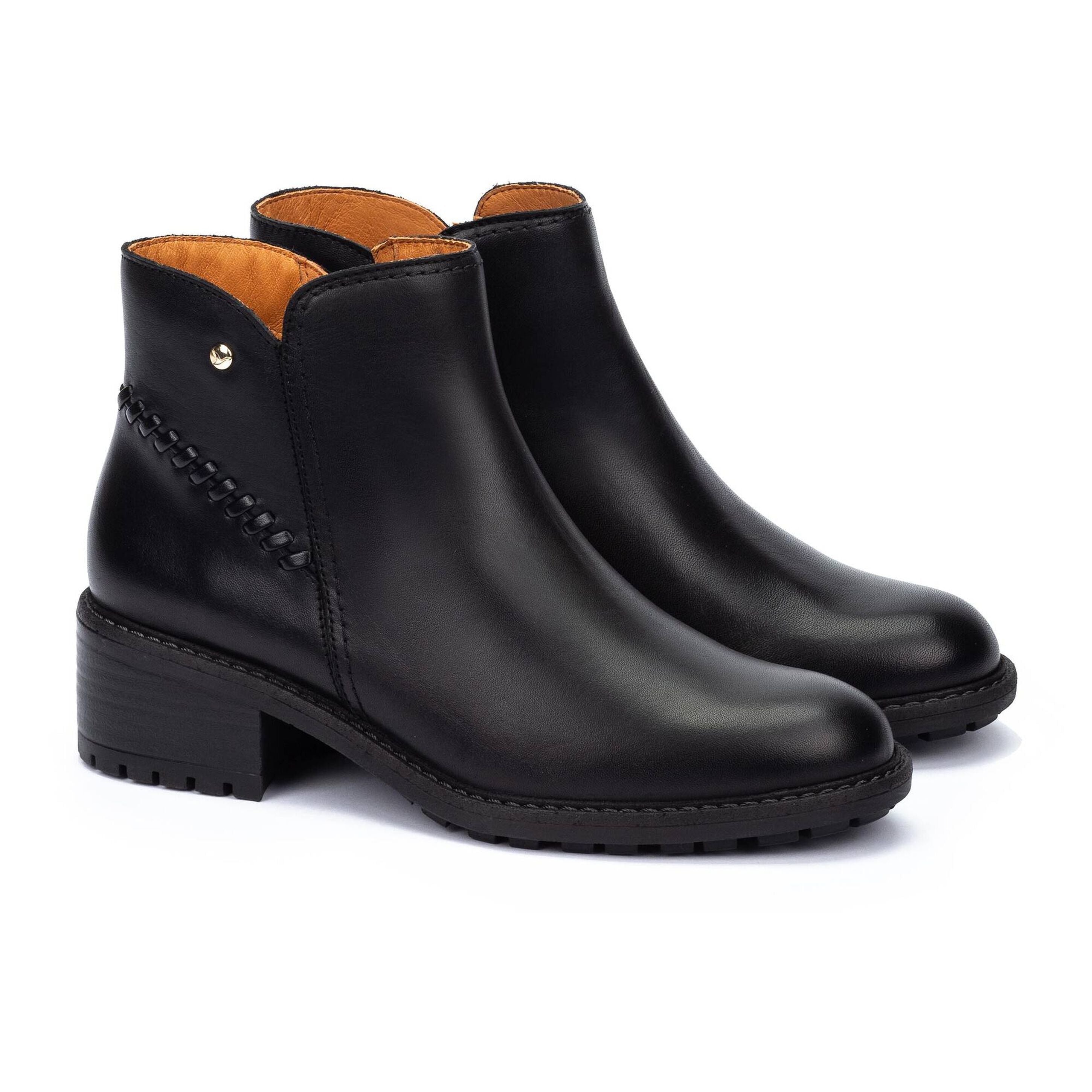 Pair of black leather ankle boots with brown interior on a white background