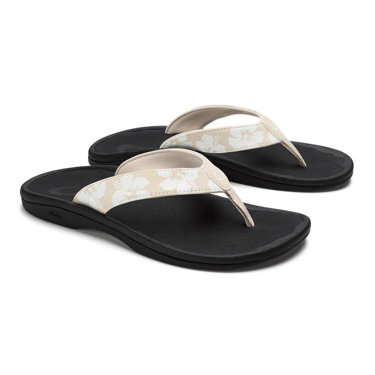 Pair of black and white floral flip-flops on a white background