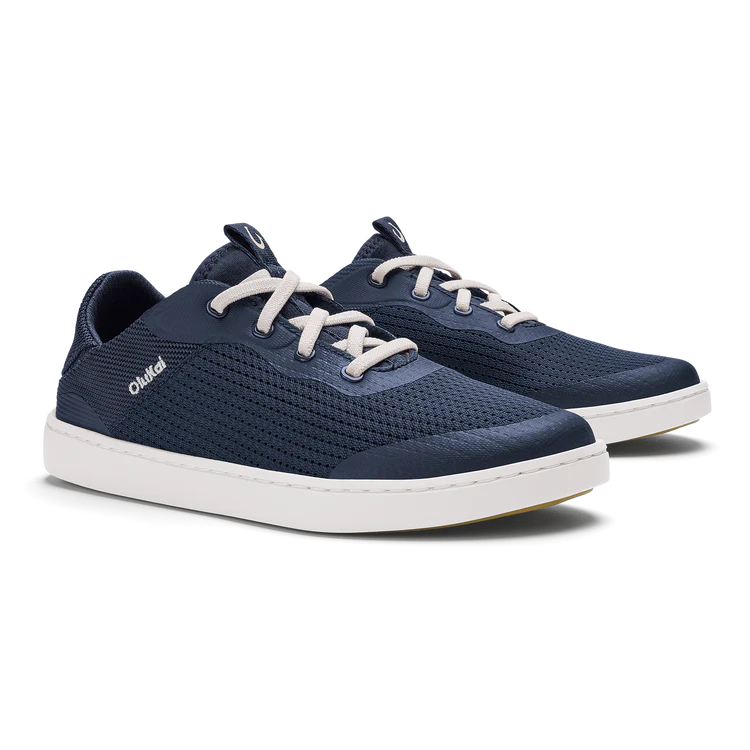 Pair of navy blue sneakers with white laces on a white background