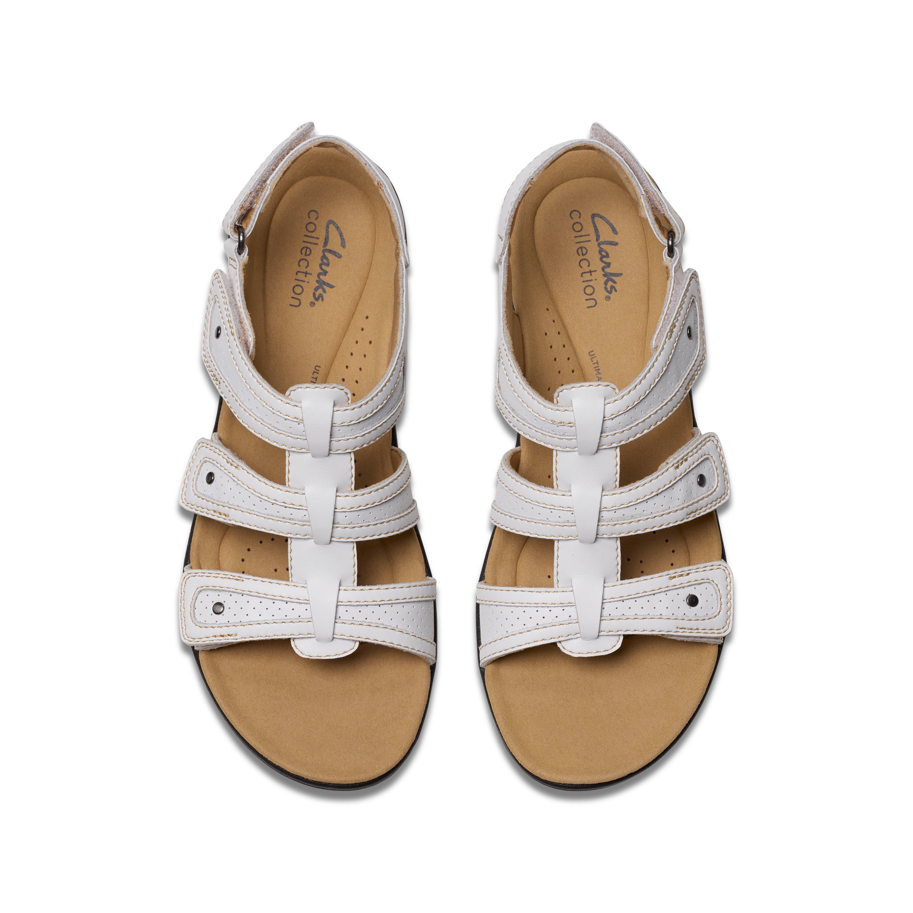 Pair of white sandals with tan soles on a white background