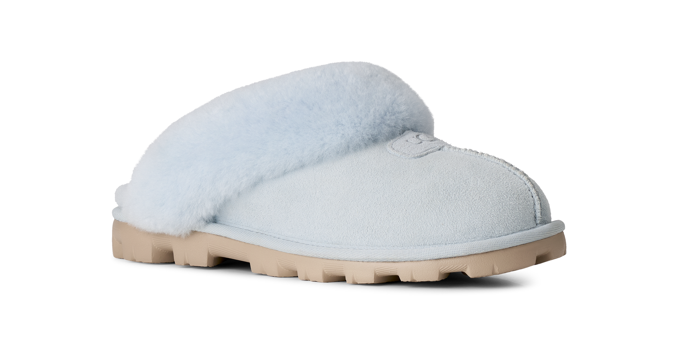 A single light blue slip-on slipper with fluffy pale blue shearling lining and a tan rubber sole, shown from a side profile on a white background.