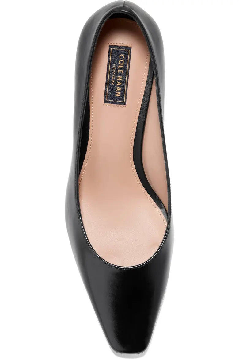A single black pointed-toe pump shoe shown from a top-down view on a plain white background. The interior lining is a light tan color, and a black brand label reading 'Cole Haan' is visible on the insole.