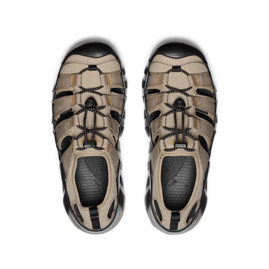 Pair of beige and black hiking shoes on a white background