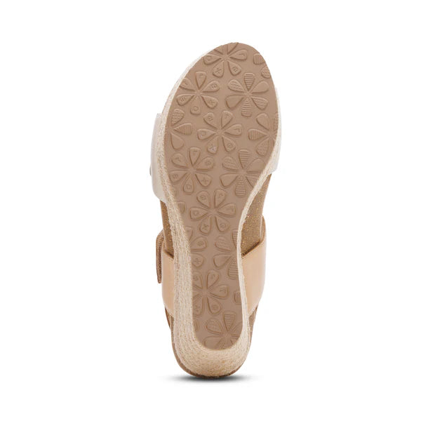 Beige sandal with a textured sole on a white background