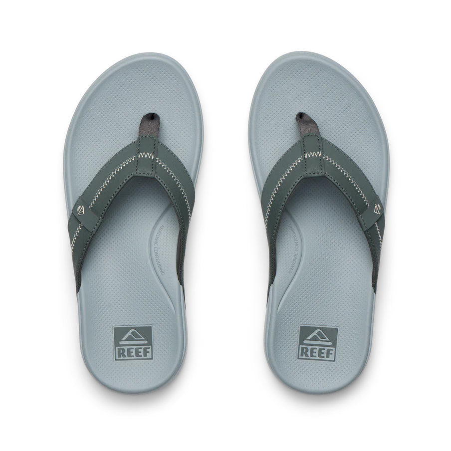 Pair of gray sandals with black straps on a white background, featuring the Reef logo.