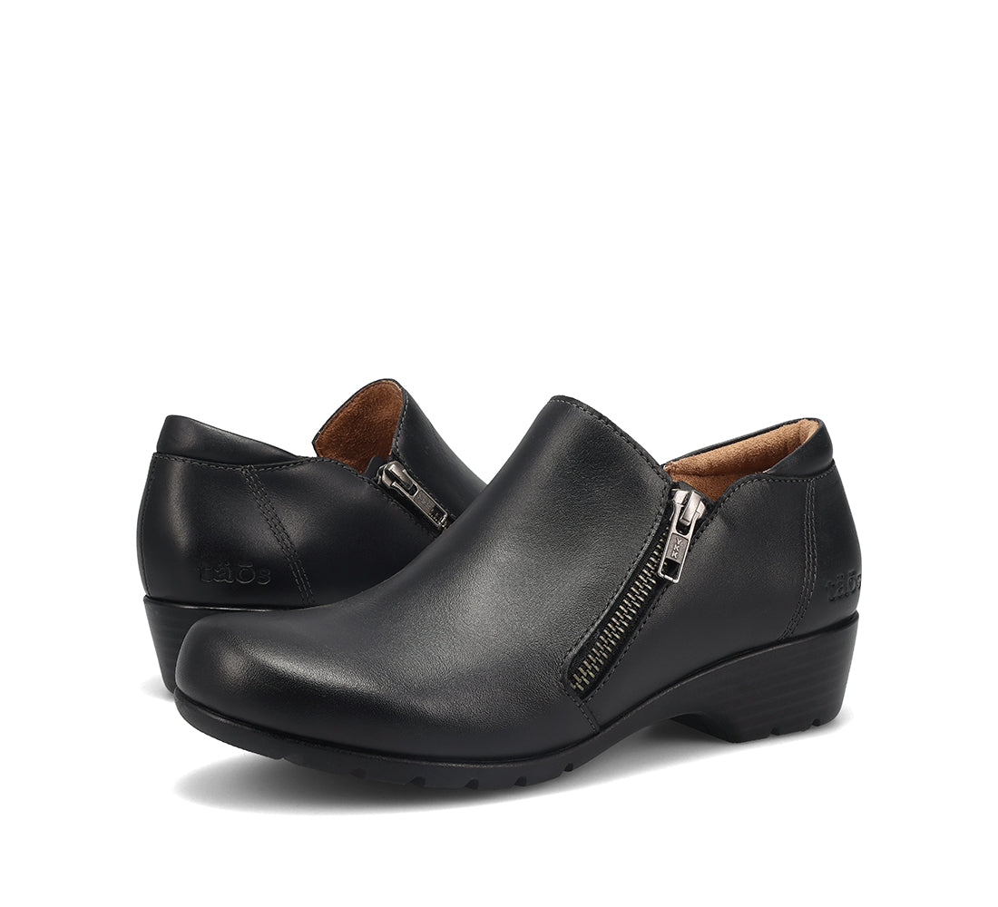 A pair of black leather slip-on wedge shoes with a side zipper, shown on a clean white background.