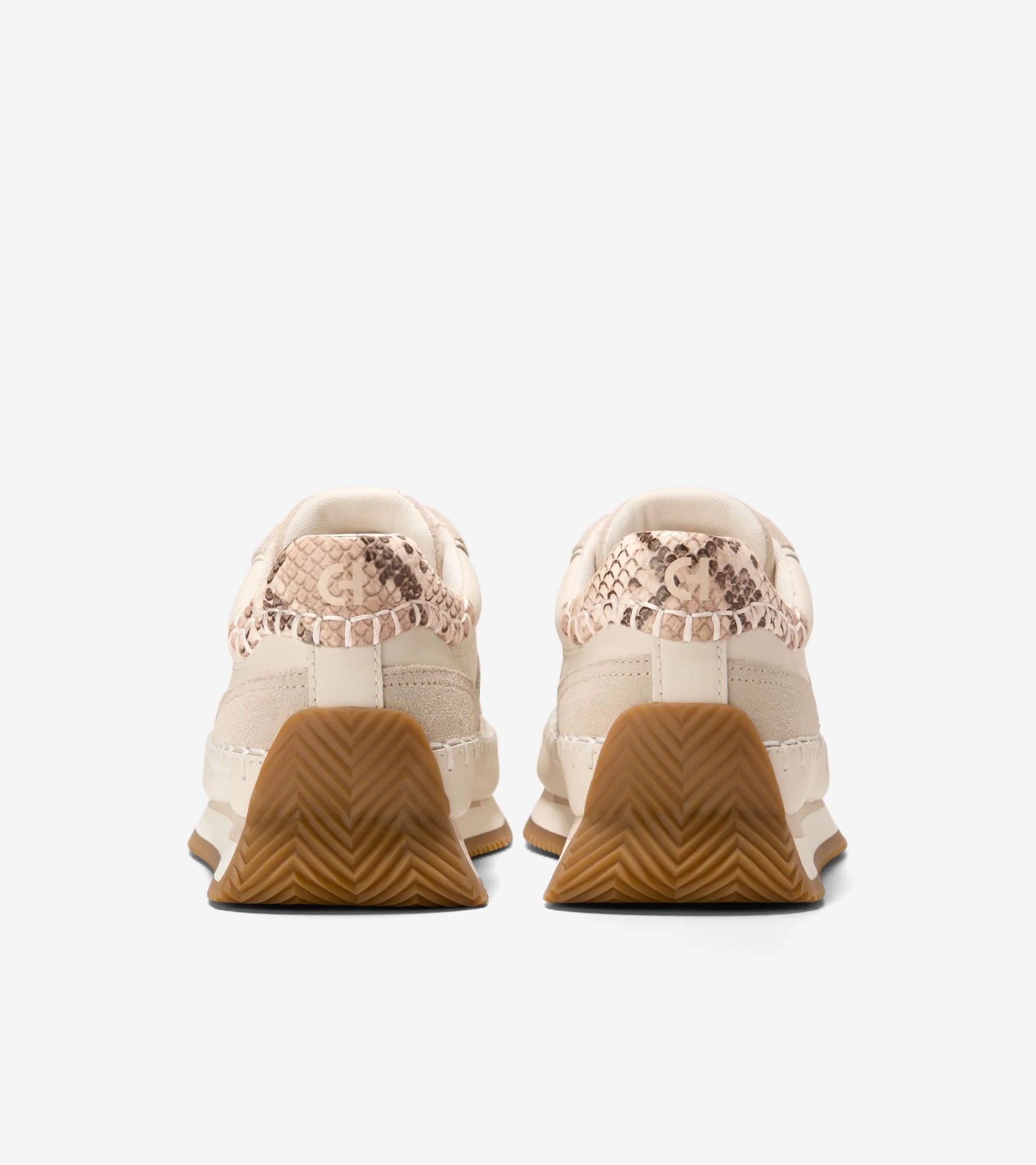 Pair of beige sneakers with brown soles on a white background