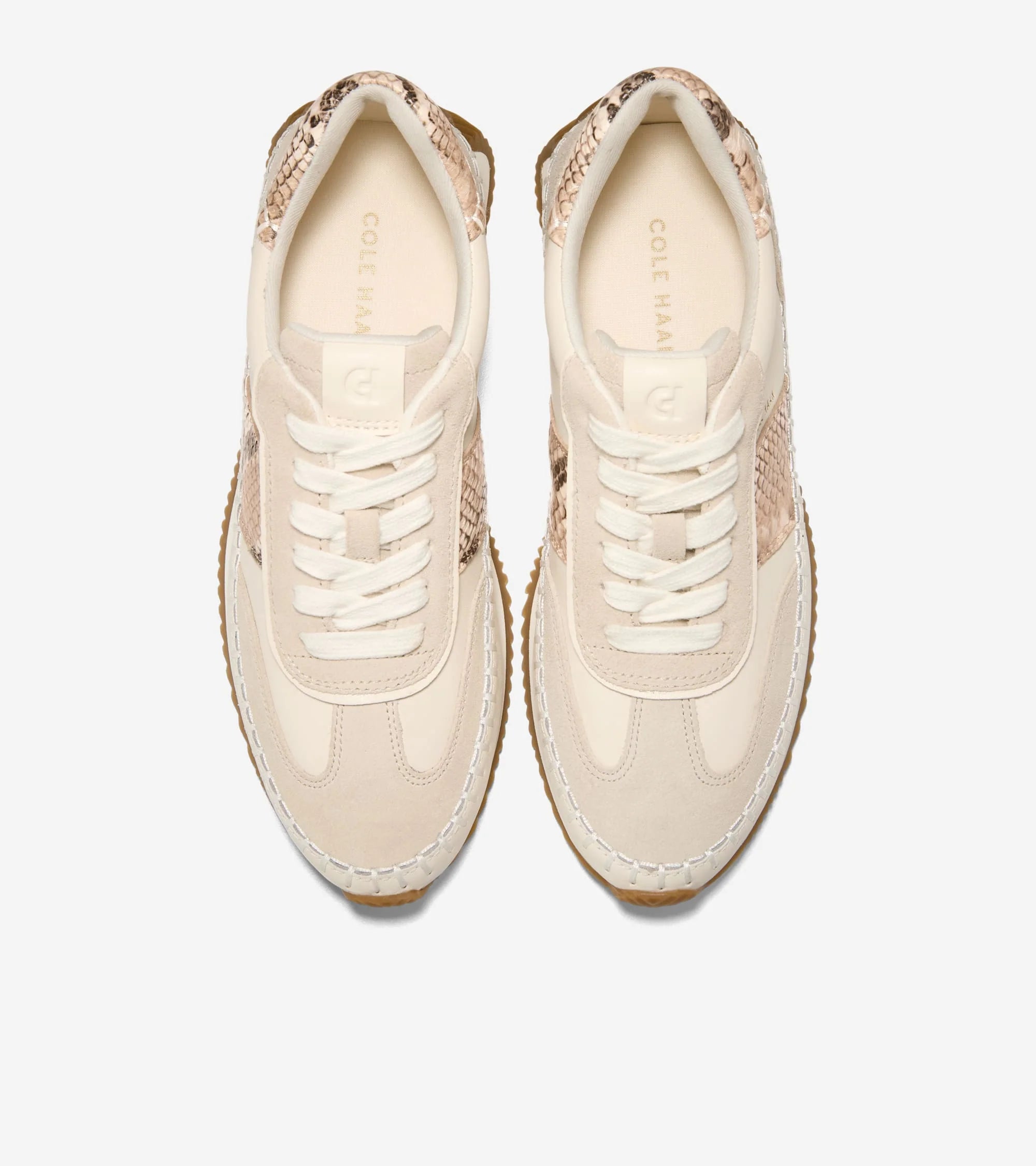 Pair of beige sneakers with lace-up design on a white background