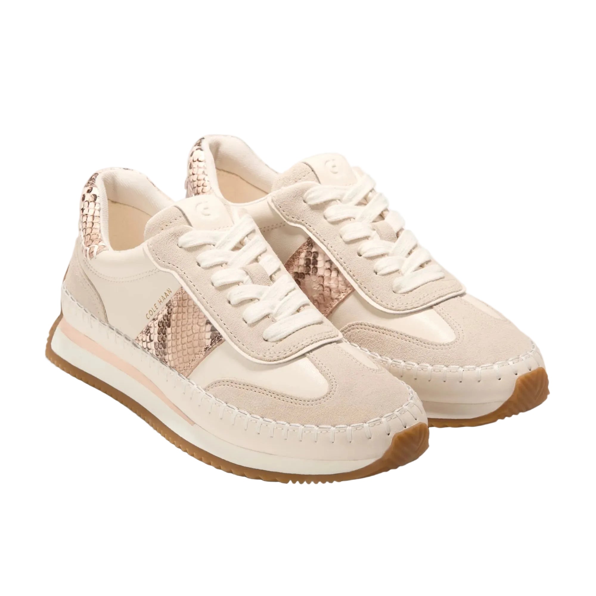 Pair of cream sneakers with brown soles on a white background