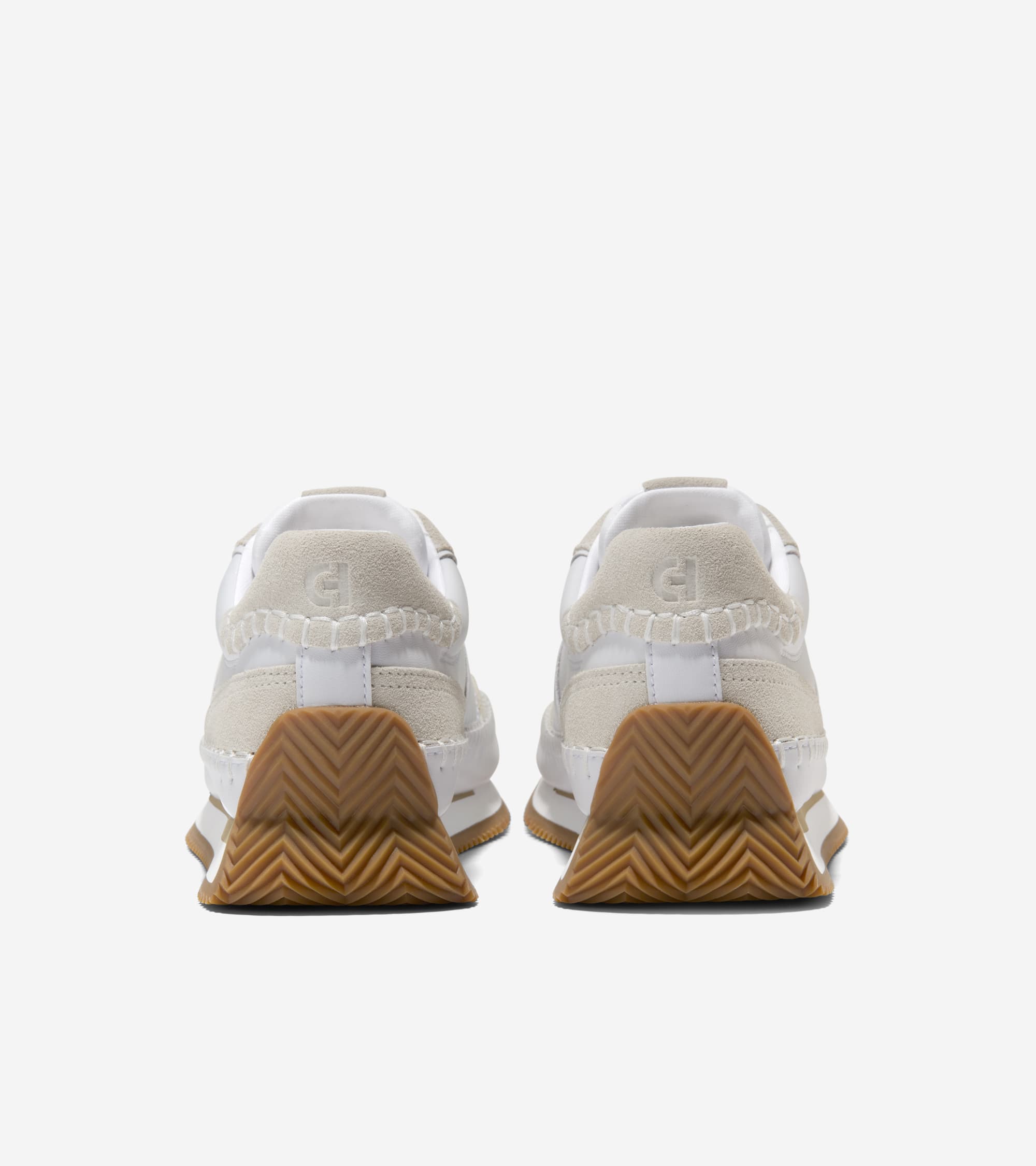 Pair of white sneakers with brown soles on a white background