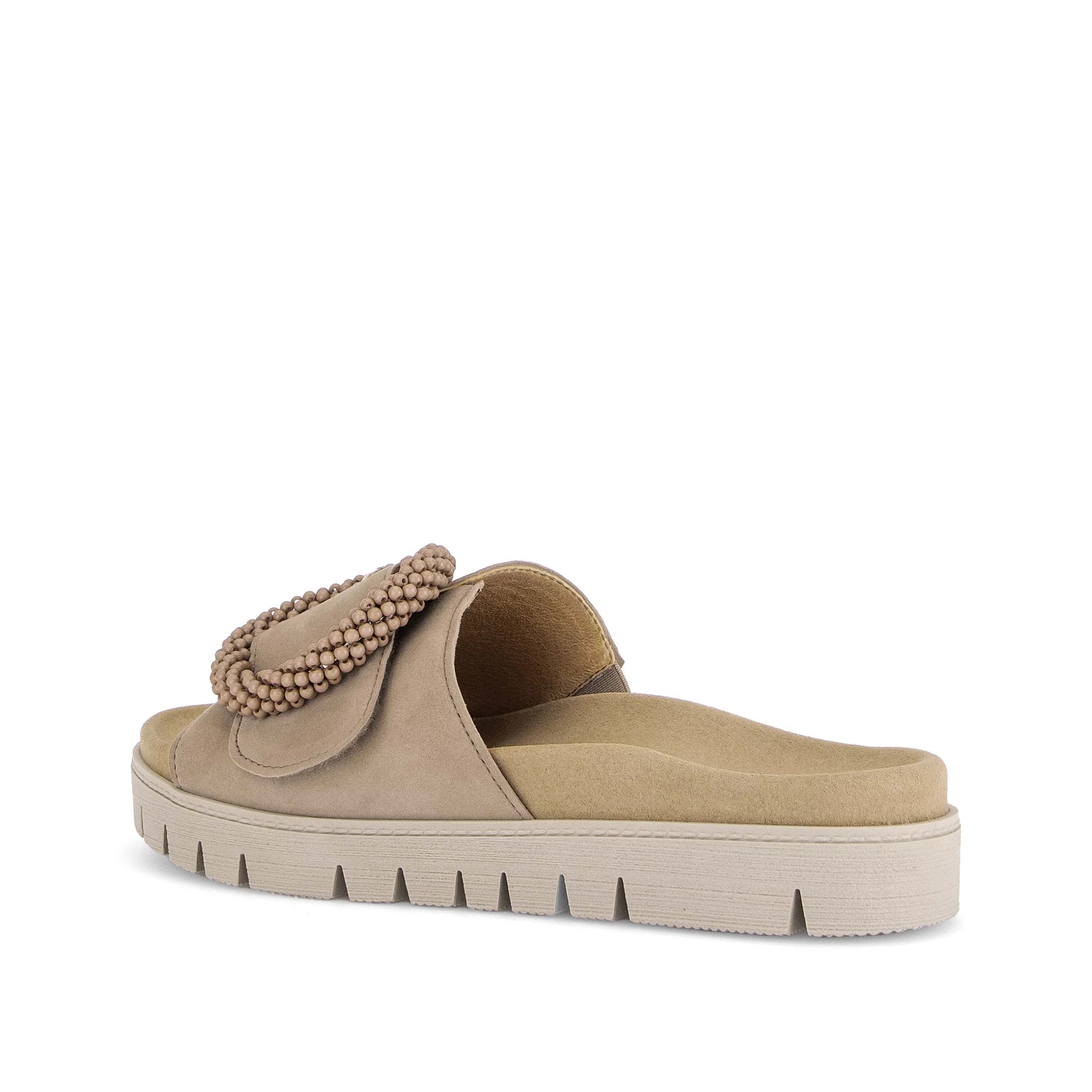 Beige sandal with a decorative strap on a white background