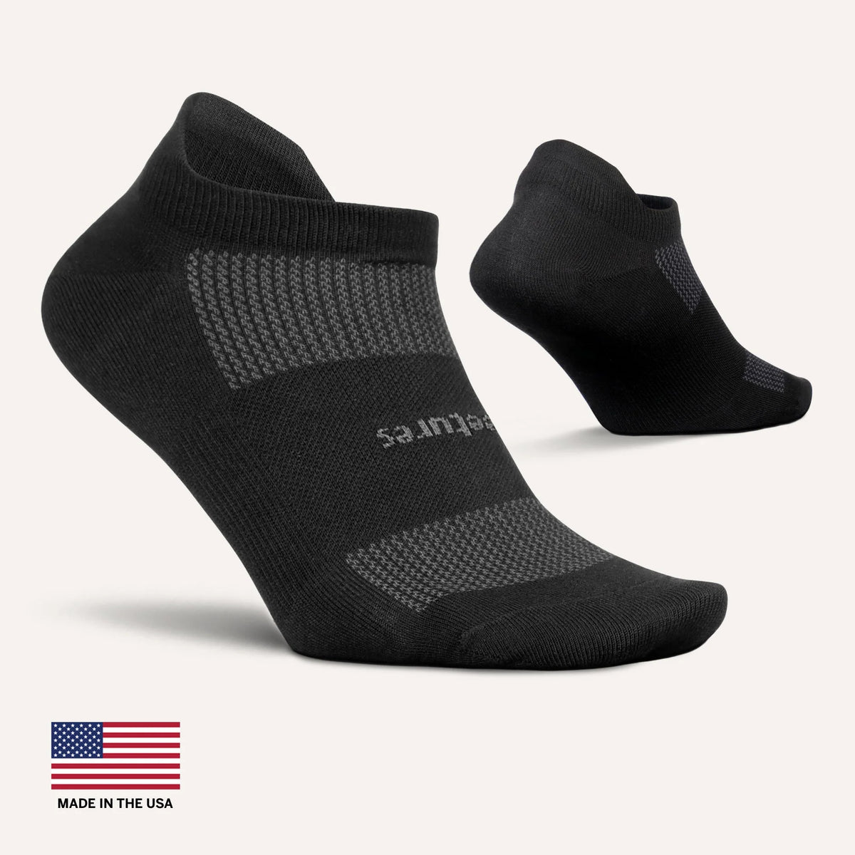 Black ankle socks with 'feetures' branding on a white background, featuring an American flag label.