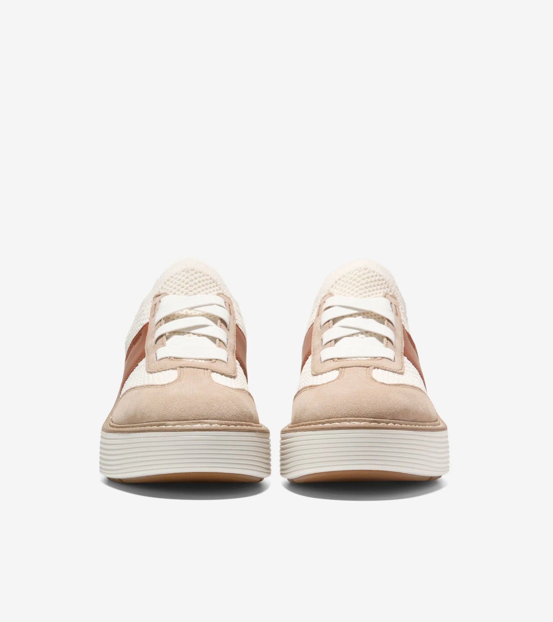 Pair of beige and white sneakers on a white background