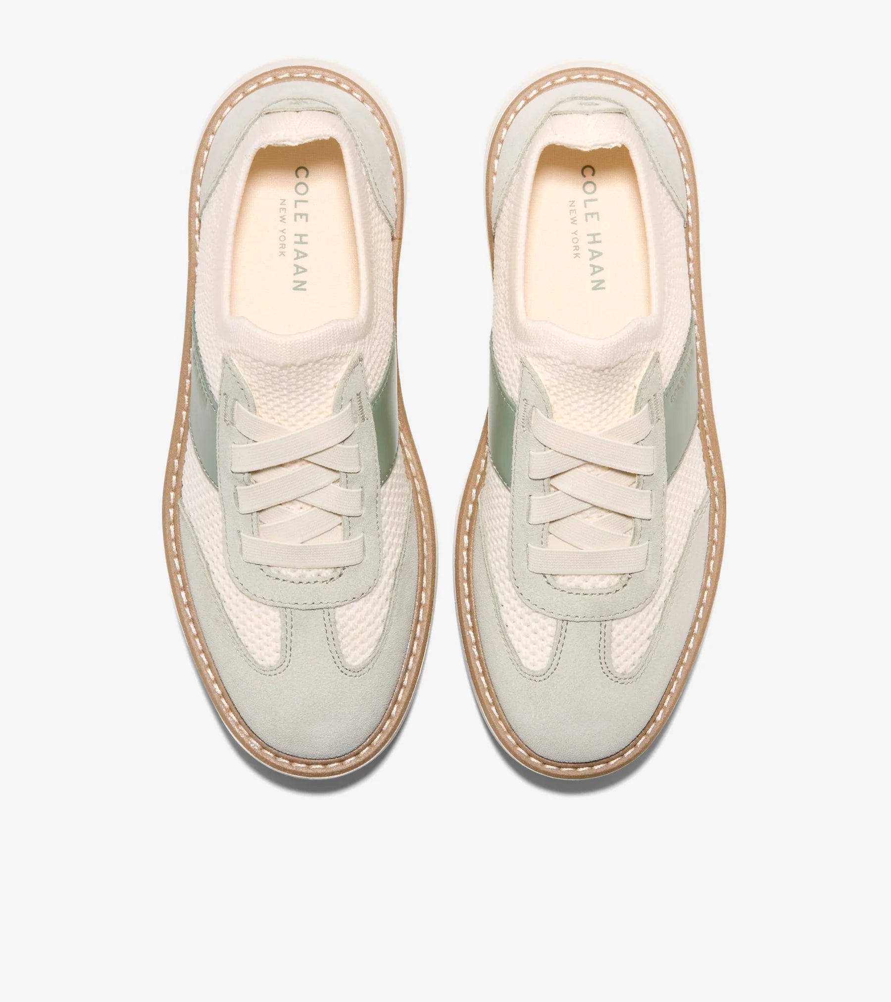 Pair of light green sneakers with beige accents on a white background
