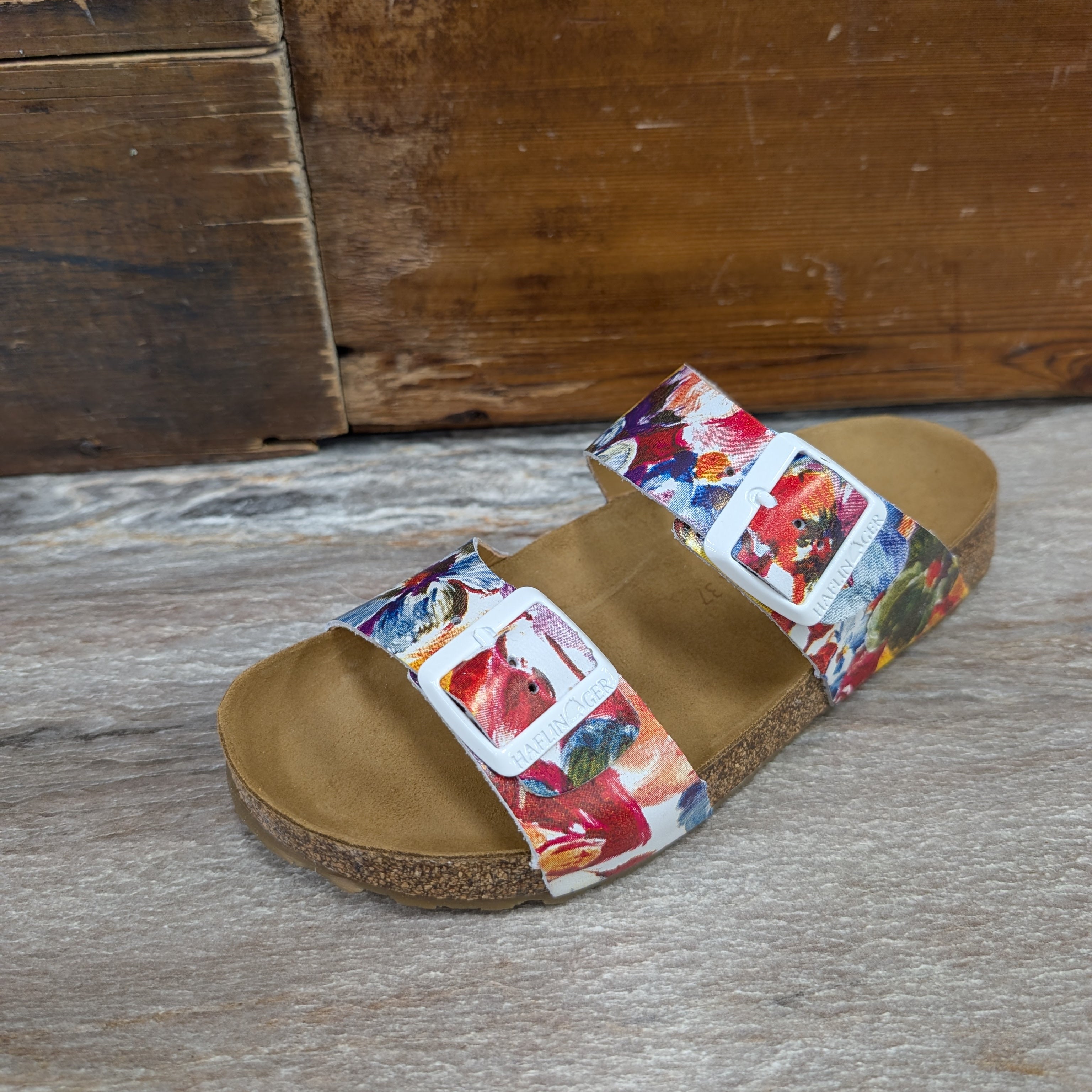 Multicolored slide sandal on a wooden floor