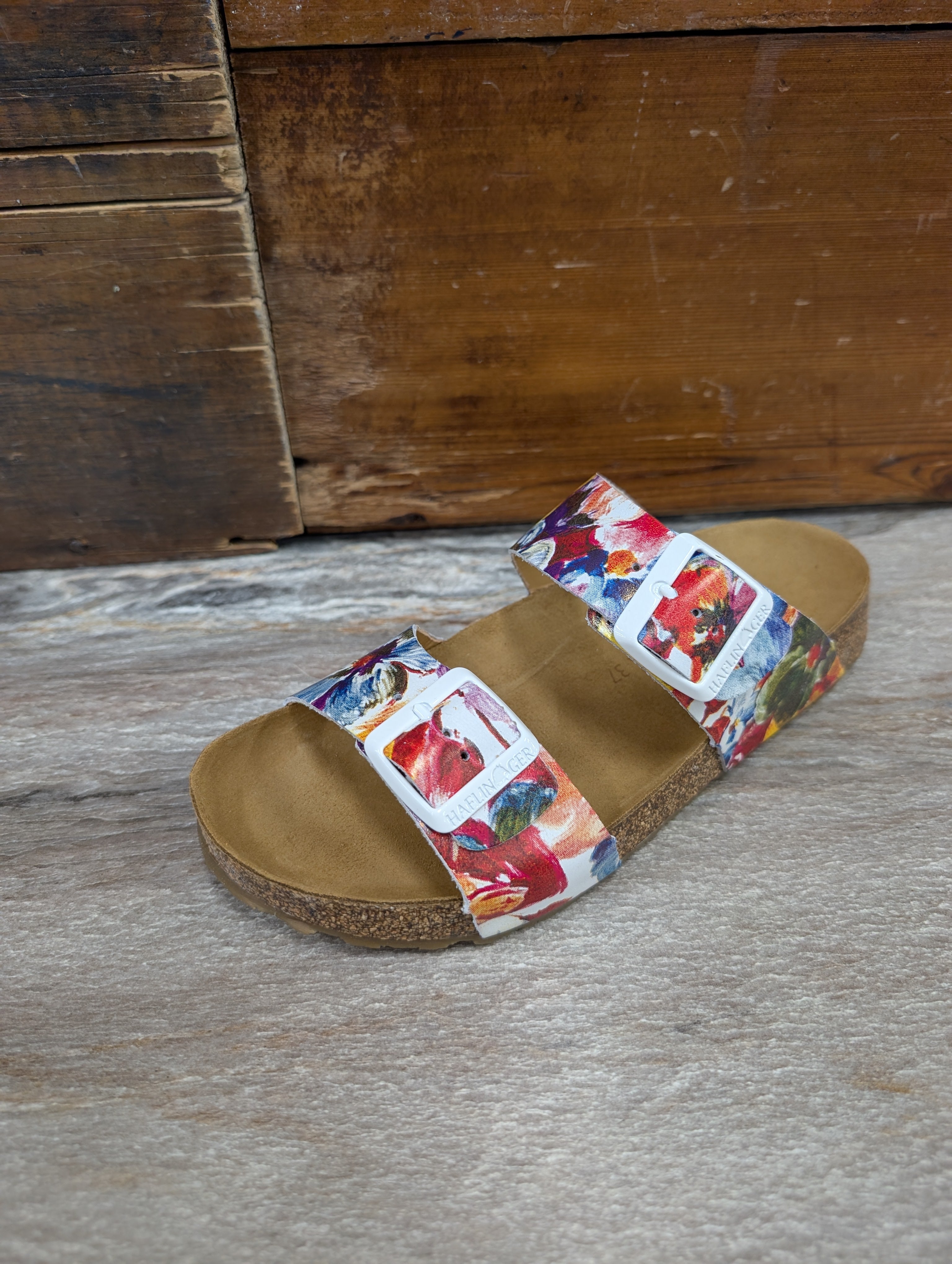 Multicolored slide sandal on a wooden floor