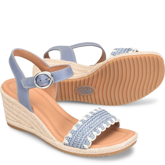 Pair of wedge sandals with blue straps and woven sole on a white background