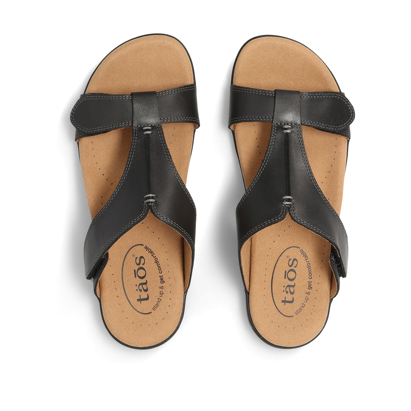 Pair of black sandals with tan soles on a white background