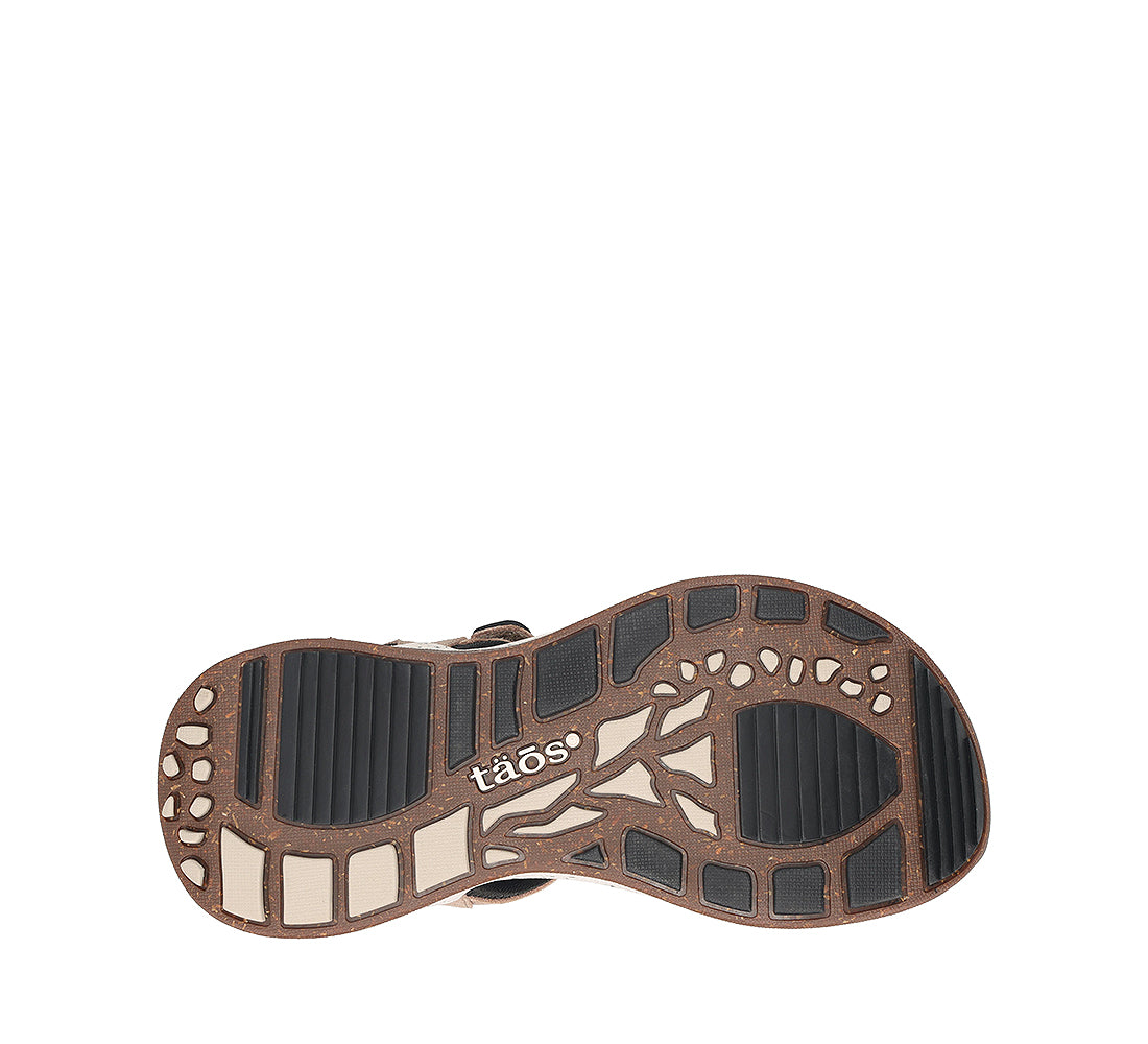 Close-up of a shoe sole with 'taos' branding on a white background