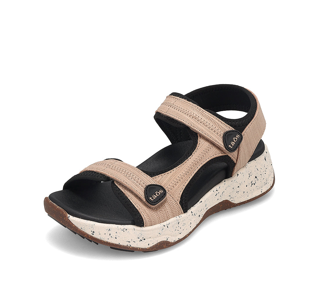 Beige sandal with black accents on a white background