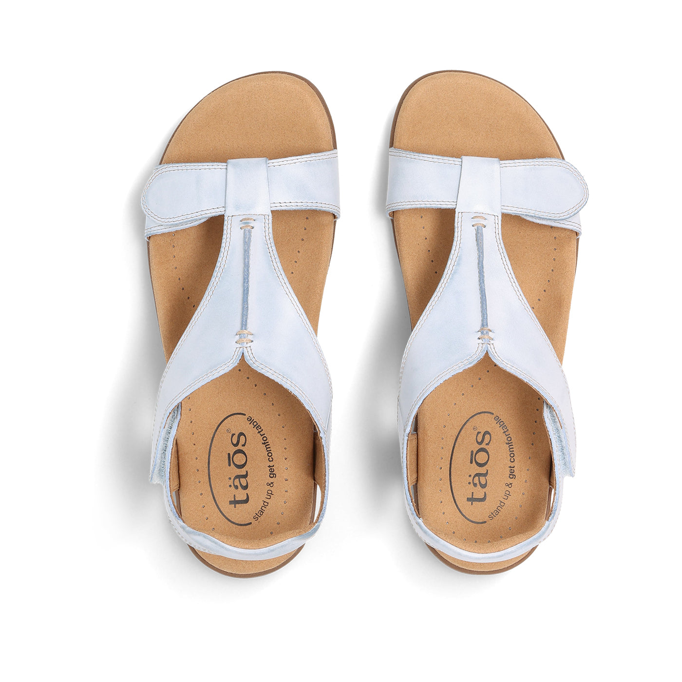 Pair of white sandals with 'taos' branding on a white background