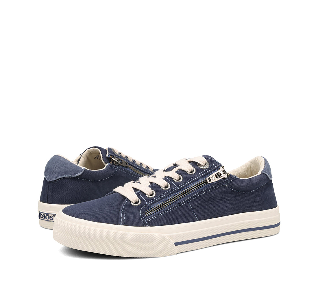 Pair of navy blue sneakers with white soles on a white background