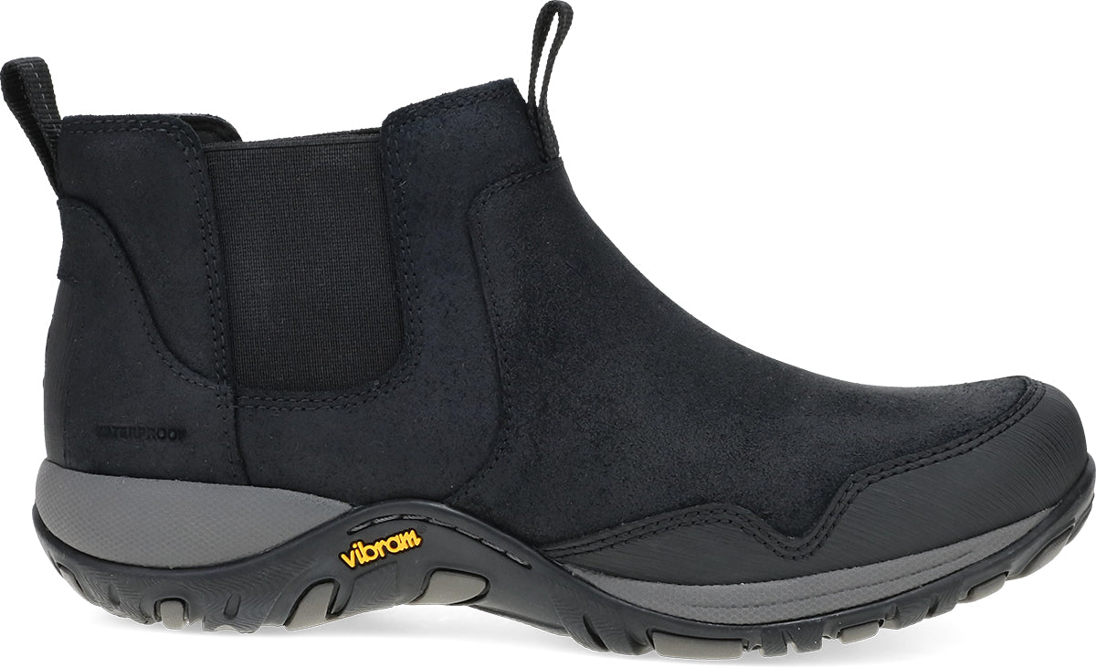 A black Chelsea-style ankle boot with a black suede and fabric upper, elastic side panels, and a gray Vibram sole, shown from a side profile on a white background.
